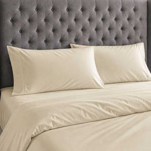 Champagne bamboo silk pillowcases and duvet cover against a grey buttoned headboard