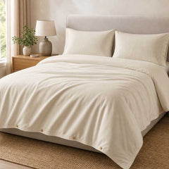 Champagne Luff SilverLining bamboo silk duvet set with matching pillowcases on a made bed in a warm neutral bedroom