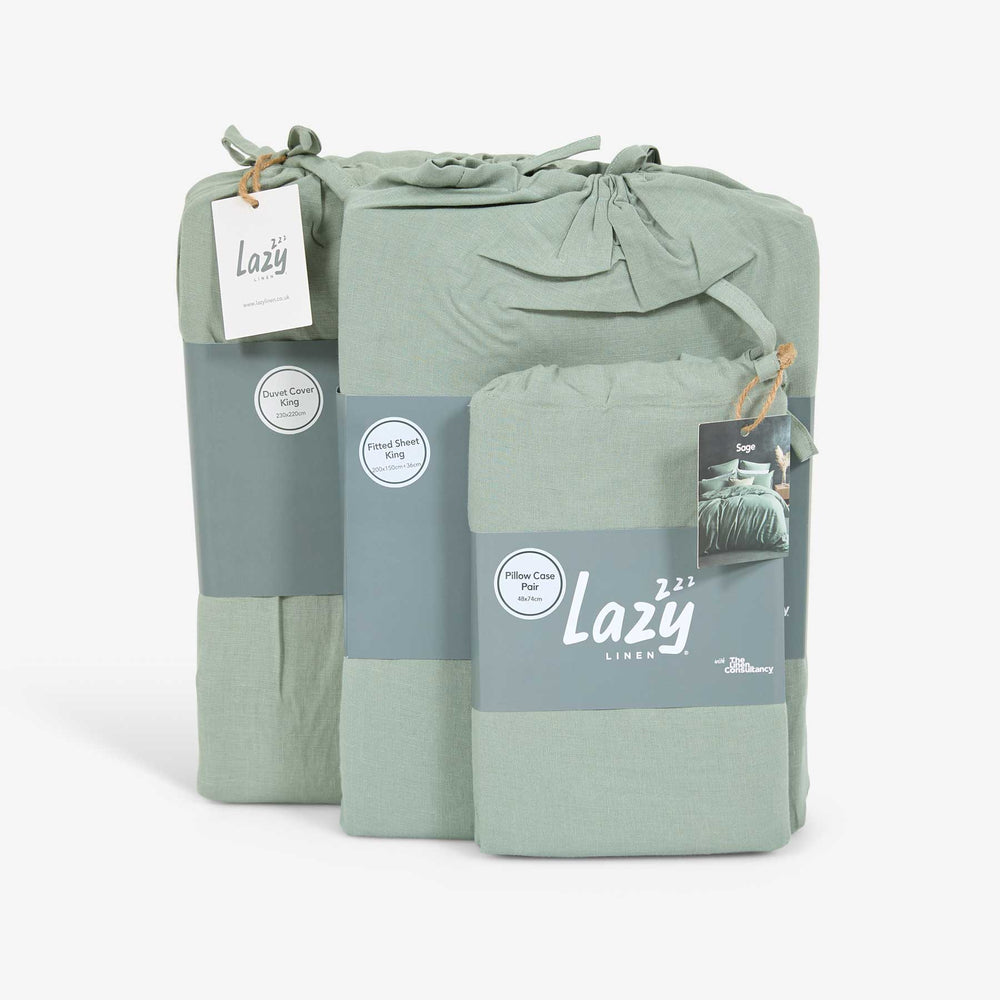 A sage green linen bedding set, including a duvet cover, fitted sheet, and two pillowcases, packaged in a bundle with a brand tag showing 'Lazy'.